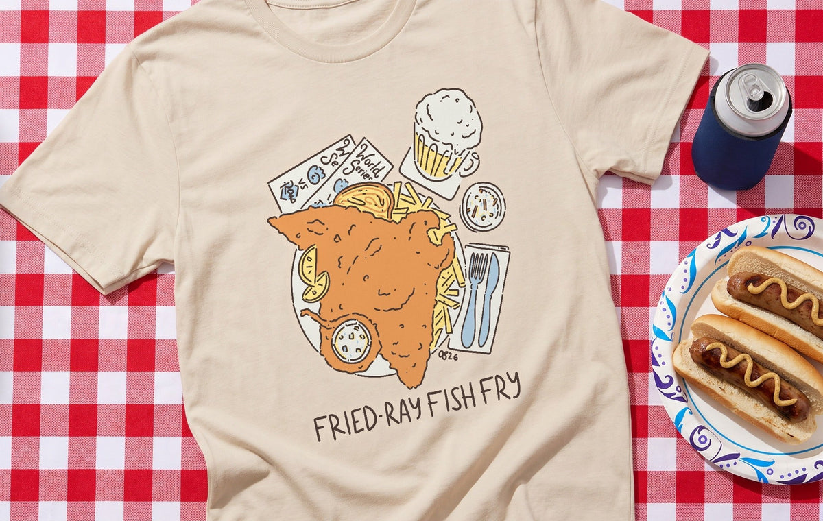 The Fried-Ray Fish Fry tee in Sand on a red checked tailgate tablecloth