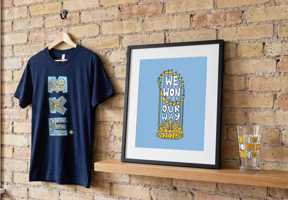 The We Won Our Way print in a frame on a cream city brick wall